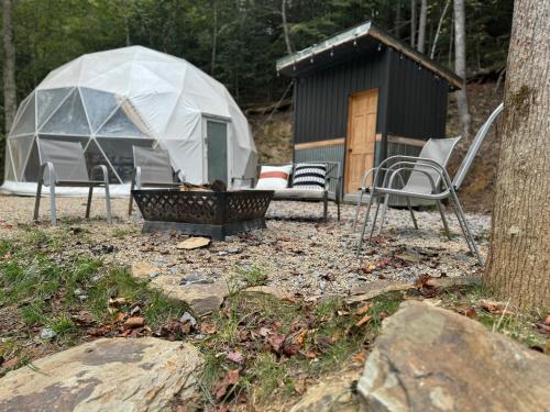 a tent and chairs in front of a building at The Perch Glamping By Rafting in Cosby