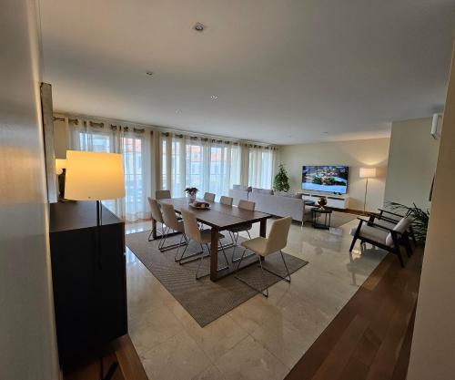 a dining room and living room with a table and chairs at Madeira Luxury Villas Living Funchal in Funchal