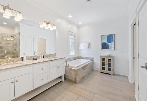 biała łazienka z wanną i dużym lustrem w obiekcie Seacrest - 113 Geoff Wilder w mieście Rosemary Beach