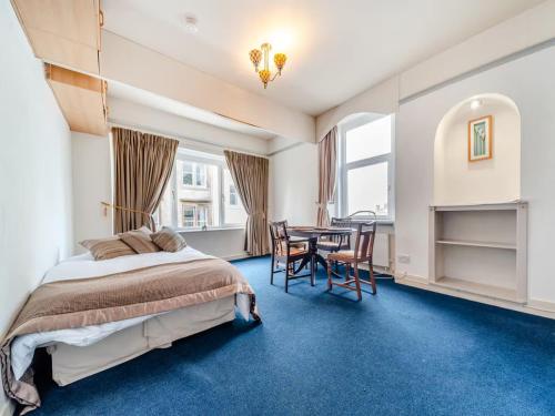 una camera da letto con un letto, un tavolo e delle sedie di Bay View a Oban