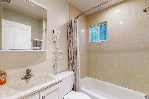 a bathroom with a tub and a toilet and a sink at Peaceful Pines Retreat in Mevers