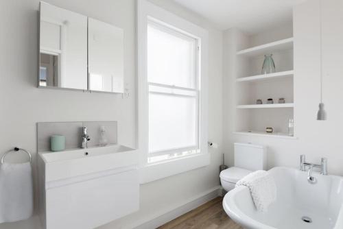 a bathroom with a sink and a toilet and a window at Charlotte Street Apartment in Bath