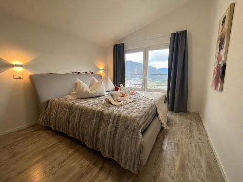 Un dormitorio con una cama con una ventana grande. en Villa Renè, en Tenno