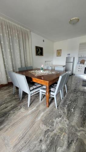 a dining room with a wooden table and chairs at Corte Azzurra Iris in Piove di Sacco