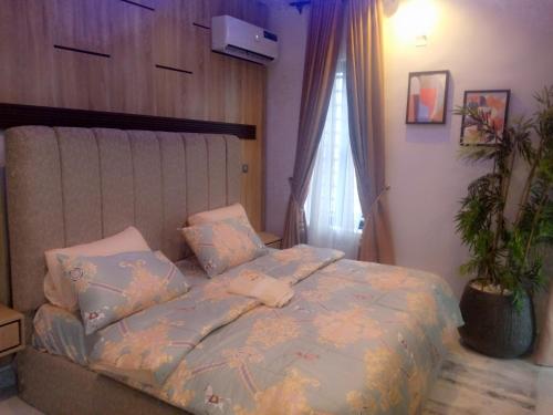 a bedroom with a bed and a potted plant at 3pila homes in Ogba