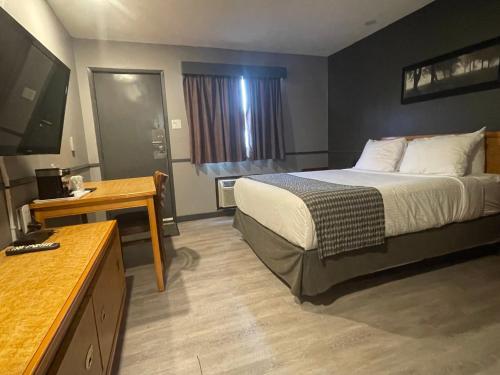 a hotel room with a bed and a flat screen tv at Travelodge by Wyndham Brandon in Brandon