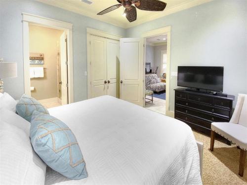a bedroom with a white bed and a flat screen tv at Inlet Beach - 70 Pinecrest in Panama City Beach