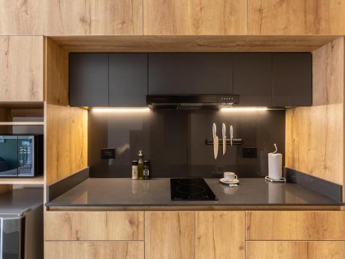 a kitchen with black cabinets and a stove top oven at Muttuo by Wynwood House in Bogotá