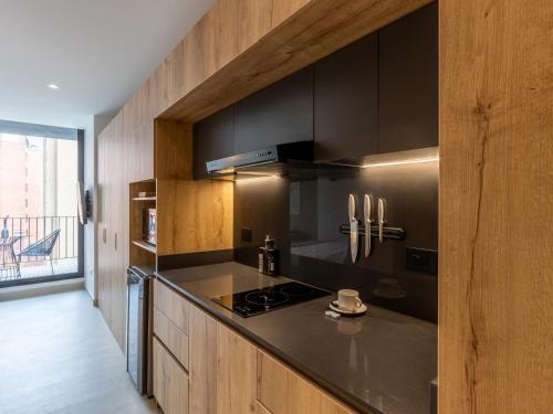 a kitchen with black cabinets and a black counter top at Muttuo by Wynwood House in Bogotá
