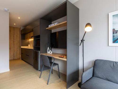 a small apartment with a desk and a chair and a couch at Muttuo by Wynwood House in Bogotá