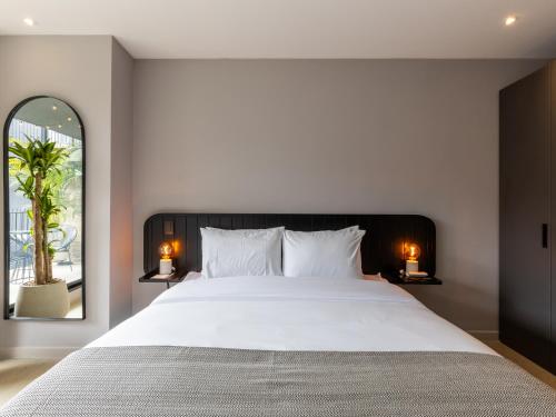 a bedroom with a large bed and a large mirror at Muttuo by Wynwood House in Bogotá