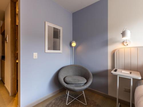 a gray chair in a room with a lamp at Muttuo by Wynwood House in Bogotá