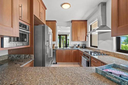 a kitchen with wooden cabinets and stainless steel appliances at Beach & Golf Course Views in Rio Grande