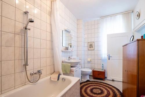 Un baño con bañera, inodoro y lavabo. en Wohnen am Park, en Diez
