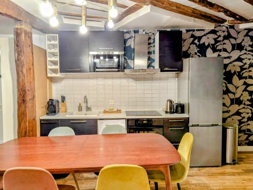 une cuisine avec une table en bois et des chaises jaunes dans l'établissement Opera Louvre HolidayApartment, à Paris