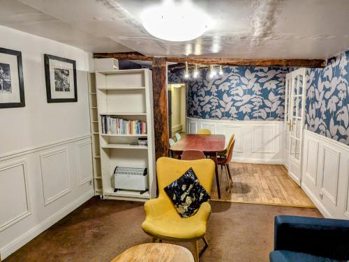 un salon avec une table et une chaise jaune dans l'établissement Opera Louvre HolidayApartment, à Paris