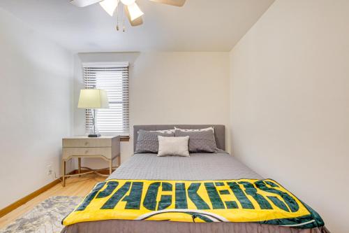 a bedroom with a bed with a yellow blanket on it at Less Than 1 Mi to Lambeau Field Green Bay Home with Grill! in Green Bay