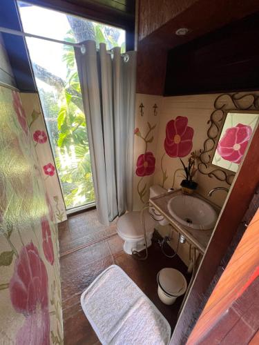 a bathroom with a sink and a toilet and a window at Rey House in Satuba