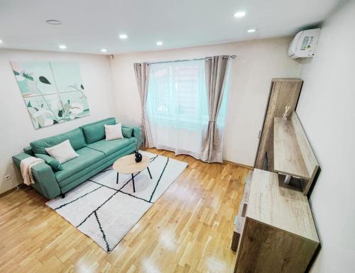 a living room with a green couch and a table at Volo House in Cluj-Napoca