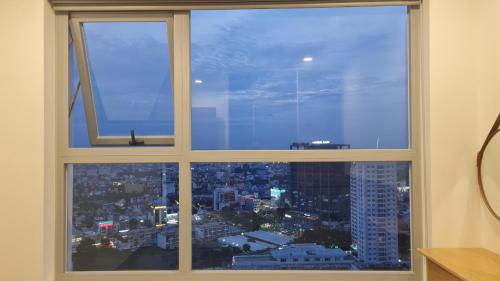 a large window with a view of a city at Teddy Codotel of Happy one central in Ấp Phú Thọ