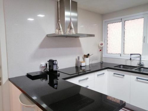 a kitchen with a black counter top and a sink at Habitaciones doble in Almussafes