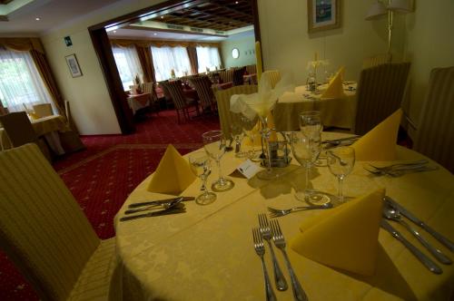 a dining room with a table with yellow napkins at Hotel Weingarten in Caldaro