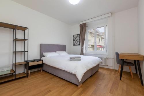 a bedroom with a bed and a desk and a window at KAYA Zurich Apartment 4A - Downtown 2BR Apt with Balcony in Zürich