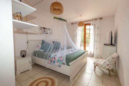 a bedroom with a bed with a mosquito net at Villa Ceyreste in Ceyreste