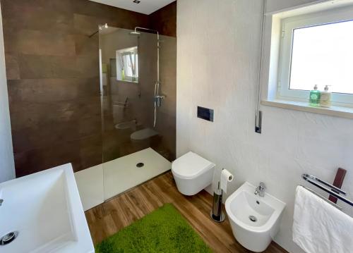 a bathroom with a sink and a toilet and a shower at Guesthouse Santos & Belos in Nazaré