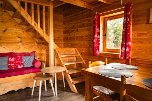 une cabane en rondins avec une table, des chaises et une fenêtre dans l'établissement La Plagne Chalet cosy calme proche valée, à La Plagne Tarentaise