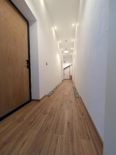 an empty hallway with a door and a wooden floor at Casa din padure in Orşova