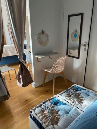 Cette chambre comprend un lit, une chaise et un miroir. dans l'établissement Vue dégagée au calme dernier etage, à Mérignac