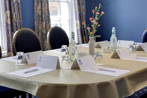 a table with white cards and bottles on it at The Rose & Crown Hotel in Tonbridge