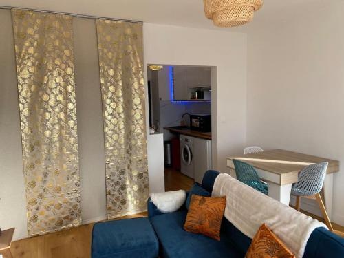 un salon avec un canapé bleu et une table dans l'établissement Vue dégagée au calme dernier etage, à Mérignac