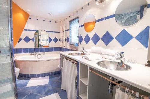 une salle de bain avec deux lavabos et une baignoire dans l'établissement Les Roches, charmante troglodyte à Amboise, à Amboise