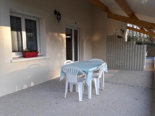 une table blanche et des chaises sur une terrasse dans l'établissement MF 9 et MF 10, à Cazaubon