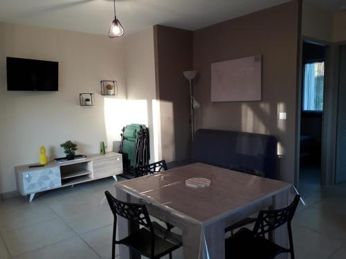 un salon avec une table, des chaises et une télévision dans l'établissement MF 9 et MF 10, à Cazaubon