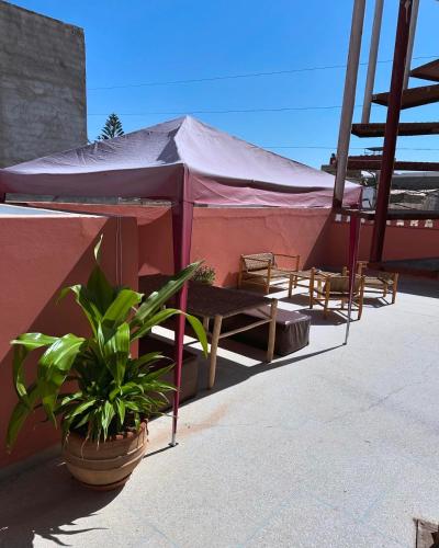 a tent with chairs and a table and a plant at Sea Surf and Sun in Tamraght Ouzdar