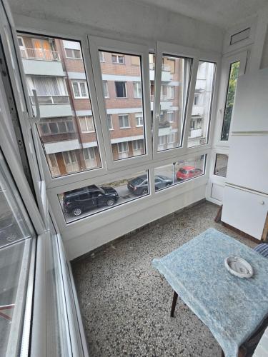 a room with three windows and a table in front of it at Stan na karaburmi in Rospi Ćuprija