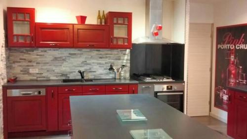 a kitchen with red cabinets and a counter top at Chez Gaston in Bourges