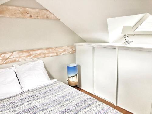 - une chambre blanche avec un lit et une lampe bleue dans l'établissement Maison bord de mer avec terrasse - Riva Bella, à Ouistreham