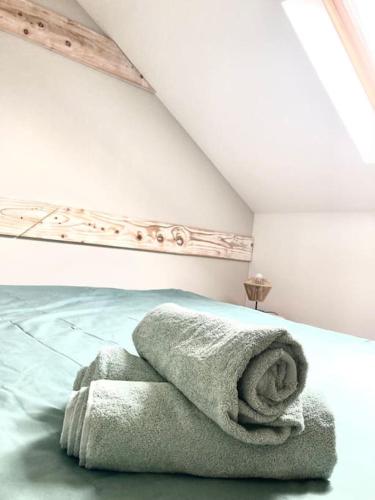 - un lit avec un tas de serviettes dans l'établissement Maison bord de mer avec terrasse - Riva Bella, à Ouistreham