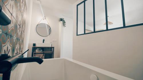 une personne peinant un mur dans une pièce avec un miroir dans l'établissement Maison La belle de Cadenet proche Lourmarin, à Cadenet