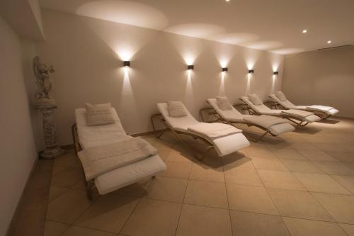 - une rangée de chaises blanches dans une salle d'attente dans l'établissement Hotel Garni Römerhof, à Innsbruck