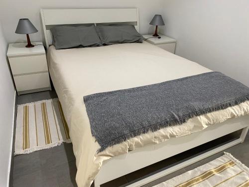 a bedroom with a large bed with two night stands at Apartamento simples e simpático in Horta