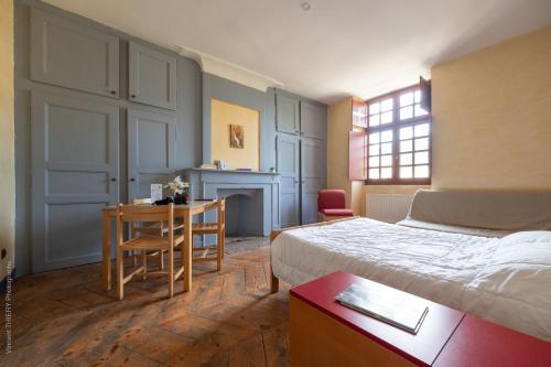 une chambre avec un lit, un bureau et une table dans l'établissement Le Pavillon des Officiers, à Mont-Dauphin