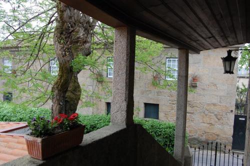 a porch with a tree and flowers in front of a building at Casa da Quinta De S. Martinho in Vila Real