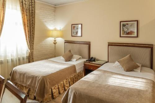 a hotel room with two beds and a window at SAMIR HOTEL in Yakkasaray