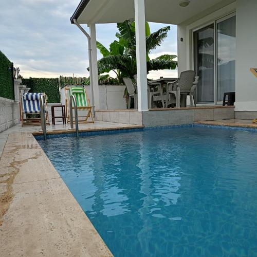 a house with a swimming pool with chairs and a table at Lavender Villas in Dalaman