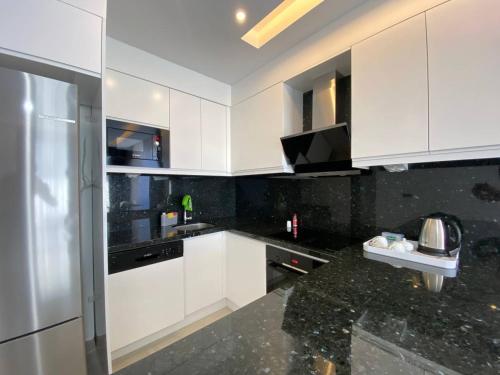 a kitchen with white cabinets and a black counter top at Boutique 16 - Alanya Experience in Alanya